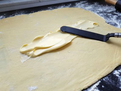 Teig ausrollen, mit Butter bestreichen