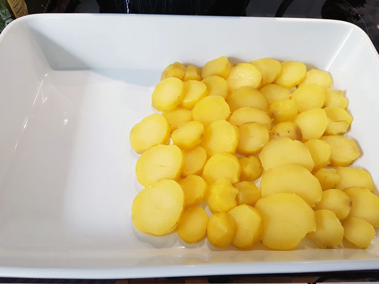 Auflaufform mit Kartoffelscheiben auslegen